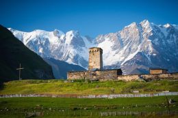 Kostel Svaté Marie v Ushguli, v pozadí nejvyšší hora Gruzie Shkara